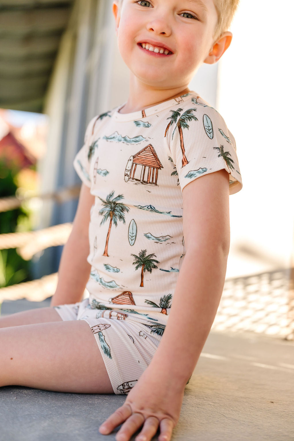 Child wearing a tropical-themed outfit with palm trees and huts.